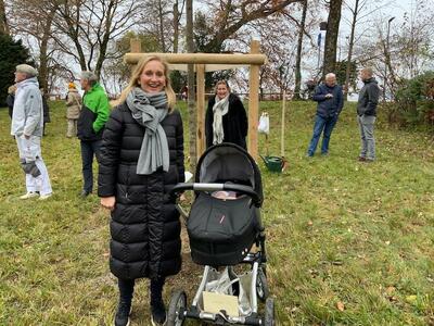 Bild vergr��ern: Oberb�rgermeisterin Dr. Claudia Alfons mit ihrem Baby vor dem Baum, den der Stadtrat ihrem Kind zur Geburt geschenkt hat.