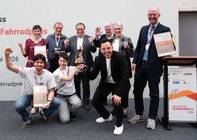 Bild vergr��ern: Sie haben den Deutschen Fahrradpreis 2026 f�r die Bodensee-Fahrradstra�e der Stadt Lindau in D�sseldorf entgegengenommen: Jaime Vald�s, Mobilit�tsmanager (3.v.r. vorne), und Norman Dietrich, Abteilungsleiter GT-Projekte (rechts).